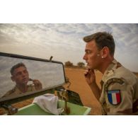 Un marsouin du 2e régiment d'infanterie de marine (RIMa) se rase dans le miroir d'une remorque-douche de campagne RD 3000 à Gao, au Mali.