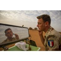 Un marsouin du 2e régiment d'infanterie de marine (RIMa) se rase dans le miroir d'une remorque-douche de campagne RD 3000 à Gao, au Mali.