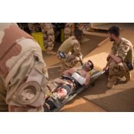 Des auxiliaires sanitaires du Service de santé des armées (SSA) évacuent un blessé au groupement médico-chirurgical (GMC) à Gao, au Mali.