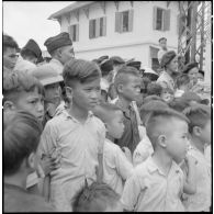 Enfants et soldats vietnamiens assistant au défilé des troupes du bataillon de marche indochinois (BMI) à Haïduong.