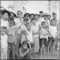 Enfants et soldats vietnamiens assistant au défilé des troupes du bataillon de marche indochinois (BMI) à Haïduong.