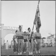 La garde au drapeau du bataillon de marche indochinois (BMI) avec le drapeau du 1er régiment de tirailleurs tonkinois (RTT) qui lui a été confié, au cours d'une cérémonie sur le stade d'Haïduong.