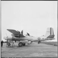 Vérification d'un avion A-26B par les mécaniciens sur le terrain d'aviation de Cat Bi.