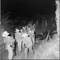 Des soldats vietnamiens armés marchant de nuit sur la route.
