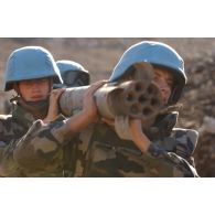 Les sapeurs du 13e RG (régiment du Génie) transportent une roquette non explosée en vue de sa destruction.