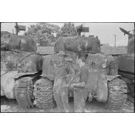 Tankistes coloniaux devant des chars Sherman alignés.