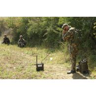 Portrait de militaires italiens en position de tir et en communication par téléphone de campagne.