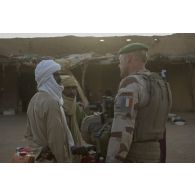 Un légionnaire du 2e régiment étranger de parachutistes (REP) discute avec le conducteur d'une moto au marché de Ménaka, au Mali.