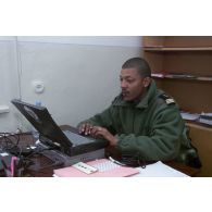 Le détachement du 1er RTP (régiment du train parachutiste) du GTO organise et affrète les avions à l'aéroport de Douchanbé. Un capitaine derrière un ordinateur dans un bureau à l'aéroport de Douchanbé.