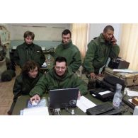 Le détachement du 1er RTP (régiment du train parachutiste) du GTO organise et affrète les avions à l'aéroport de Douchanbé. Personnels dans un bureau, dont deux convoyeuses de l'Air et deux capitaines.