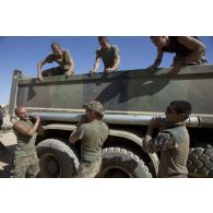 Des soldats déchargent une roquette prise aux terroristes depuis la benne d'un camion à Tessalit, au Mali.