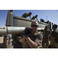 Des soldats déchargent une roquette prise aux terroristes depuis la benne d'un camion à Tessalit, au Mali.