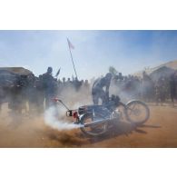 Un civil malien fait fumer sa moto au passage des troupes françaises à Korioumé, au Mali.