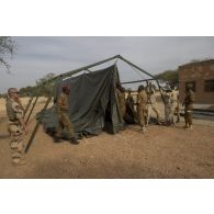 Un instructeur du Service de santé des armées (SSA) encadre le montage d'un module sanitaire par des stagiaires burkinabè à Dori, au Burkina Faso.