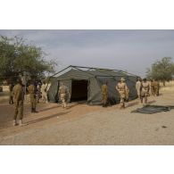 Des instructeurs du Service de santé des armées (SSA) encadrent le montage d'un module sanitaire par des stagiaires burkinabè à Dori, au Burkina Faso.