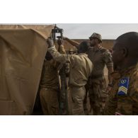 Un instructeur du Service de santé des armées (SSA) encadre le montage d'un module sanitaire par des stagiaires burkinabè à Dori, au Burkina Faso.