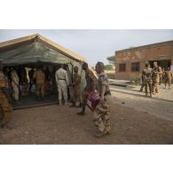 Des instructeurs du Service de santé des armées (SSA) encadrent le montage d'un module sanitaire par des stagiaires burkinabè à Dori, au Burkina Faso.