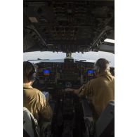 Des pilotes manoeuvrent à bord du cockpit de leur avion Boeing C-135 FR en vol au-dessus du Mali.