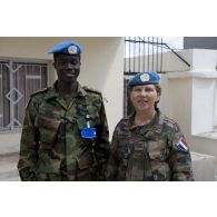 Photographie de groupe d'un capitaine féminin français et d'un militaire ghanéen des CIMIC.