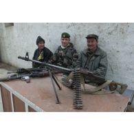 Portrait de groupe d'un capitaine légionnaire officier communication en compagnie de deux combattants de l'Alliance du Nord à l'aéroport de Mazar e Charif.