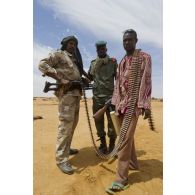 Des soldats maliens font un point de situation avec un milicien pour la sécurisation du périmètre autour de Gao, au Mali.