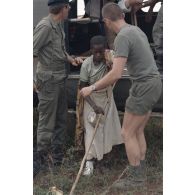Un militaire français aide une réfugiée blessée à descendre de l'hélicoptère de transport Puma à Cyangugu, lors de son évacuation sanitaire effectuée par l'élément militaire médical d'intervention rapide (EMMIR) du camp de Kibeho.