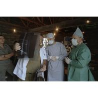 Examen d'une radiographie de la broche sur la jambe du patient à l'issue de l'opération chirurgicale en coopération franco-israélienne à Goma.