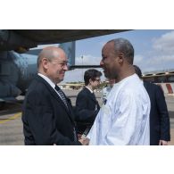Le ministre de la Défense Jean-Yves Le Drian est accueilli par un personnel diplomatique ivoirien à son arrivée à Abidjan, en Côte d'Ivoire.