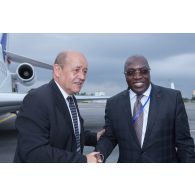 Le ministre de la Défense Jean-Yves Le Drian est accueilli par son homologue ivoirien Paul Koffi Koffi à son arrivée à Abidjan, en Côte d'Ivoire.