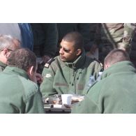 Dernier déjeuner en plein air des derniers militaires du détachement français présents à l'aéroport de Mazar e Charif avec des plateaux repas. Portrait du capitaine du DTIA (détachement de transit interarmées).
