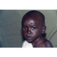Portrait d'un enfant réfugié soigné sous une tente de l'élément militaire médical d'intervention rapide (EMMIR).