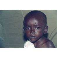 Portrait d'un enfant réfugié soigné sous une tente de l'élément militaire médical d'intervention rapide (EMMIR).