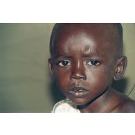 Portrait d'un enfant réfugié soigné sous une tente de l'élément militaire médical d'intervention rapide (EMMIR).