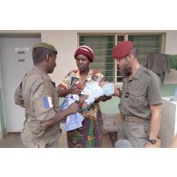 Une femme rwandaise portant son bébé discute avec l'aumônier Richard Kalka, du 3e régiment parachutiste d'infanterie de marine (3e RPIMa) et un légionnaire, à l'entrée de la salle de consultation à l'hôpital Saint-François à Cyangugu.
