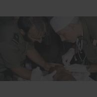 Réhydratation d'une petite fille par l'infirmier réserviste adjudant Xuereb (barbu) et par le médecin réserviste capitaine Xavier Sauvageon, anesthésiste-réanimateur à l'hôpital Dieu à Paris, à l'antenne chirurgicale aérotransportable (ACA) de Goma.