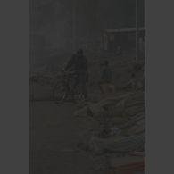 Un militaire zaïrois à vélo longe les cadavres abandonnés rangés au bord de la route au poste-frontière de Goma-Gisenyi.