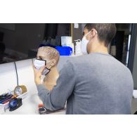 Un ingénieur de la DGA vérifie l'état général d'un masque sur la tête d'un mannequin au centre technique du Bouchet.