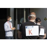 Un ingénieur présente le contenu de différents ateliers à des participants, lors d'une expérimentation de l'application StopCovid au sein des locaux de l'INRIA.