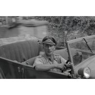 Un capitaine (Hauptmann) de la Luftwaffe aux commandes d'un véhicule (conduite à droite), il pourrait s'agir d'un véhicule de prise.