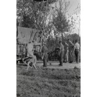 Dépannage d'une voiture par une grue Kfz-Aufsetzkran 3t installée sur un camion Opel Blitz.