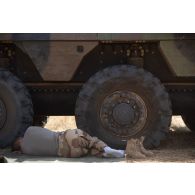 Un soldat du 16e bataillon de chasseurs à pied (16e BCP) se repose à l'ombre de son véhicule blindé de combat d'infanterie (VBCI) dans la région de Tofagala, au Burkina Faso.