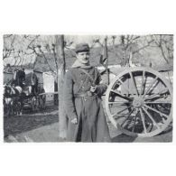 [Un soldat du service de santé (infirmier ?) se tient la pipe à la main devant une charrette].