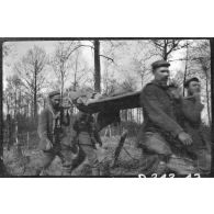 [Des soldats transportent un blessé sur un brancard].