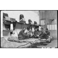 [Des soldats jouent aux cartes dans une chambrée].