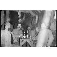 [Un groupe de soldats assis autour d'une table dans un abri].