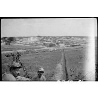 [Deux soldats devant une carrière en arrière plan].