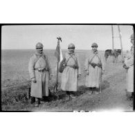 [Portrait de trois soldats du 32e régiment d'infanterie avec leur drapeau].