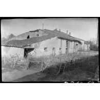 [Chevaux de frise et barbelés devant un bâtiment].