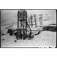 [Soldats devant des pylônes électriques dans un paysage enneigé].