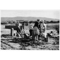 Femmes algériennes se ravitaillant en eau auprès de pompes. [légende d'origine]<br>